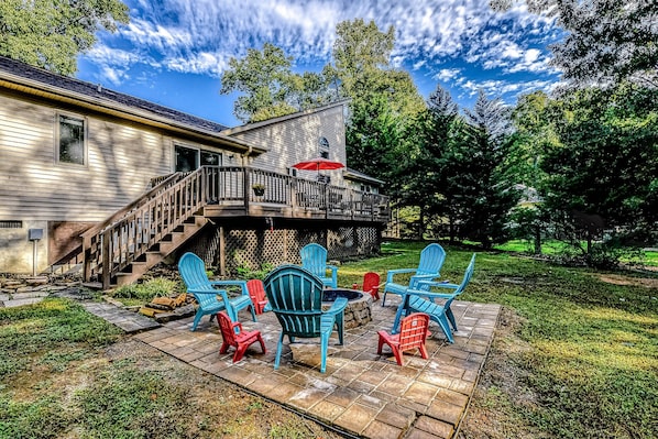 A house with a deck, outdoor seating, and a staircase leading to the upper level. - Dog-friendly Home With Free Wifi, Central AC, Firepit, & Furnished Deck (Mineral)