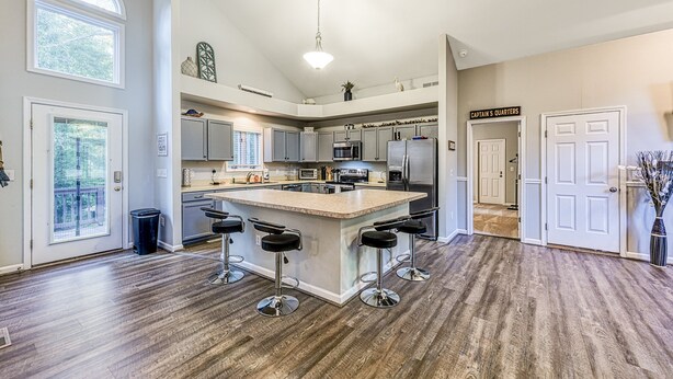A modern kitchen with a central island, bar stools, and a sign reading 'Captain's Quarters'. - Dog-friendly Home With Free Wifi, Central AC, Firepit, & Furnished Deck (Mineral)