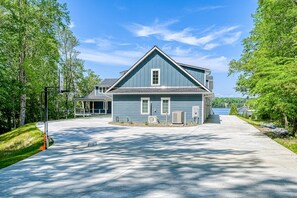 A two-story house with a gabled roof, a covered porch, and a view of a lake. - Dog-friendly Lakefront Home With a Game Room, Children's Items, and Firepit (Mineral)