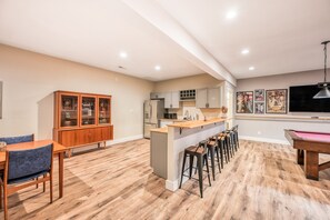 A modern kitchen with a bar area, wooden cabinets, and a pool table. - Dog-friendly Lakefront Home With a Game Room, Children's Items, and Firepit (Mineral)
