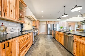 A spacious kitchen with wooden cabinets, stainless steel appliances, and a farmhouse-style decor.