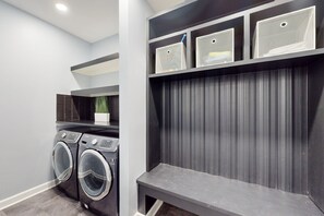 A laundry room with two front-loading washers, a bench, and storage shelves. - Dog-friendly Spacious House W/private Pool, Private Pool Table & Ping Pong Table (Mineral)