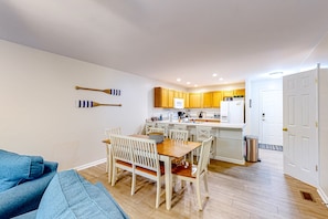 A compact living space with a dining area, kitchenette, and a door leading to another room. - Lakefront Home With Kayaks, Private Patio, air Hockey, Grill, & Balcony (Mineral)
