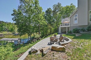 A house with a patio overlooking a lake, surrounded by trees. - Spacious Lakefront Home w/ Boat Dock, Fire pit & Pool Table - Dogs OK (Mineral)
