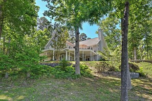 A large house with a covered porch, surrounded by trees and greenery. - Spacious Lakefront Home w/ Boat Dock, Fire pit & Pool Table - Dogs OK (Mineral)