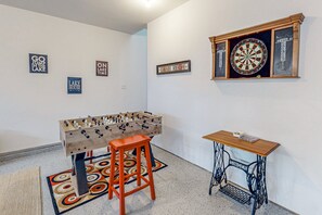 A room with a foosball table, a dartboard, and a sewing machine table. - Renovated Lakehouse With Dock, hot Tub, Firepit & Bi-level Deck - Dogs OK (Mineral)