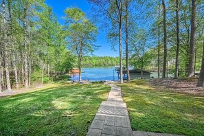 A pathway leading to a lake with a dock, surrounded by trees and a small building. - Secluded Lakefront Home W/private Beach, Deck, gas Grill, Firepit, Lake Views (Bumpass)