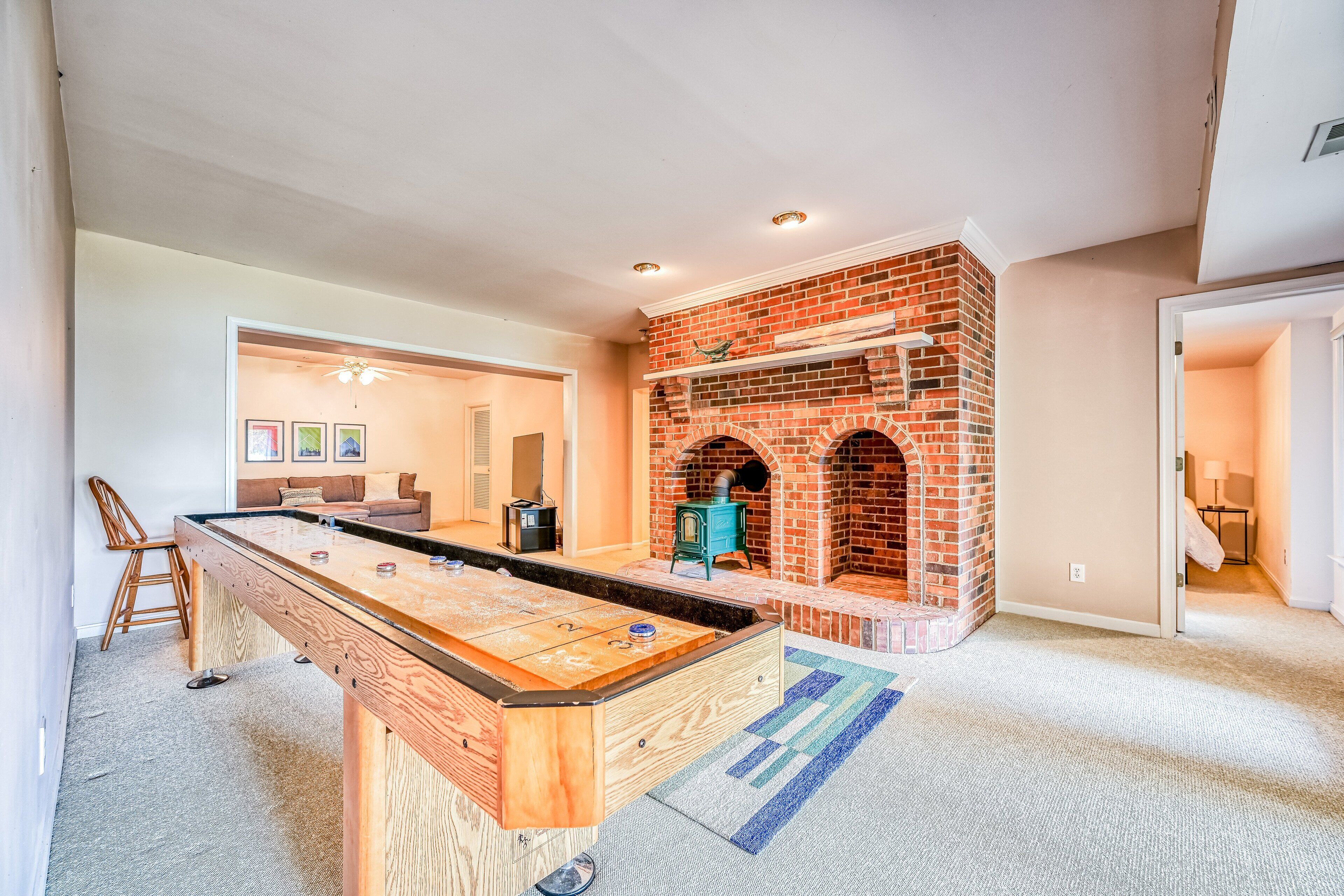 A room with a pool table, a fireplace, and a cozy seating area.