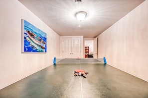 A hallway with a ping pong table, a door, and a painting on the wall. - Lakefront Home in Private Location With Dock, Firepit, Game Room & Pickleball (Mineral)