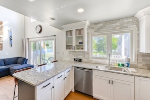 A kitchen with white cabinets, a granite countertop, a dishwasher, and a window with a view of the outdoors. - Three-story Lakefront Home w/ Covered Boat Slip, and Tennis/pickleball Access (Mineral)