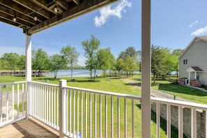 A covered porch with a view of a lake, a grassy area, and a house. - Three-story Lakefront Home w/ Covered Boat Slip, and Tennis/pickleball Access (Mineral)
