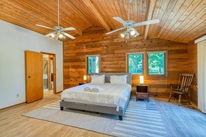 A bedroom with a wooden ceiling, two ceiling fans, a bed with white bedding, two bedside tables with lamps, and a window with a view of trees. - Lakefront Retreat W/private Dock, Fast Wifi, gas Grill & Central AC, Dogs (Mineral)