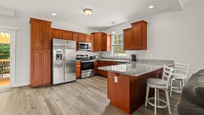 A modern kitchen with wooden cabinets, stainless steel appliances, and a granite countertop. - Lakeview Escape Near Beach With Fenced dog Run, Porch & Dock With one Boat Slip (Louisa)