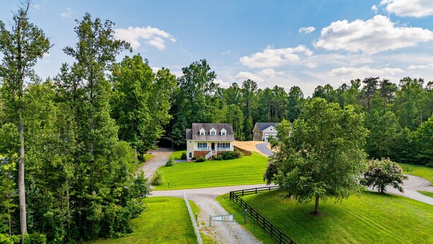 A large house with a well-maintained lawn, surrounded by dense trees. - Lakeview Escape Near Beach With Fenced dog Run, Porch & Dock With one Boat Slip (Louisa)