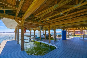 Eine Holzterrasse mit Pool, Sitzgelegenheit und Blick auf das Wasser.
