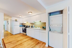 A modern kitchen with white cabinets, a built-in oven, and a dishwasher.