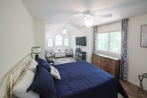 A bedroom with a bed, a desk, a television, and a ceiling fan. - Spacious pet Friendly Waterfront House With Patio & Grill (Bumpass)