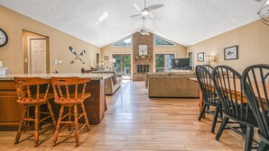 Una cocina amplia con suelo de madera, una isla central y un comedor con sillas.