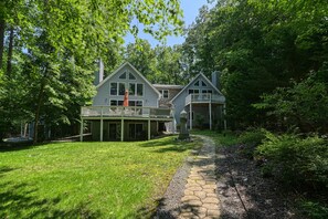A two-story house with a covered porch and a stone pathway leading to the entrance. - Lakefront Oasis With Free Wifi, Private Dock, Furnished Deck, & Paddleboards (Bumpass)