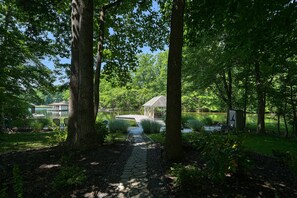 A stone pathway leading to a gazebo in a lush garden with a lake and dock. - Lakefront Oasis With Free Wifi, Private Dock, Furnished Deck, & Paddleboards (Bumpass)