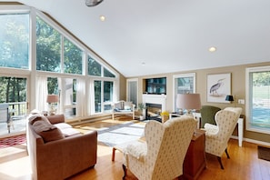 A spacious living room with large windows, a fireplace, and a view of the outdoors. - Spacious pet Friendly House W/private Pool Table, Ping Pong Table & Free Wifi (Bumpass)