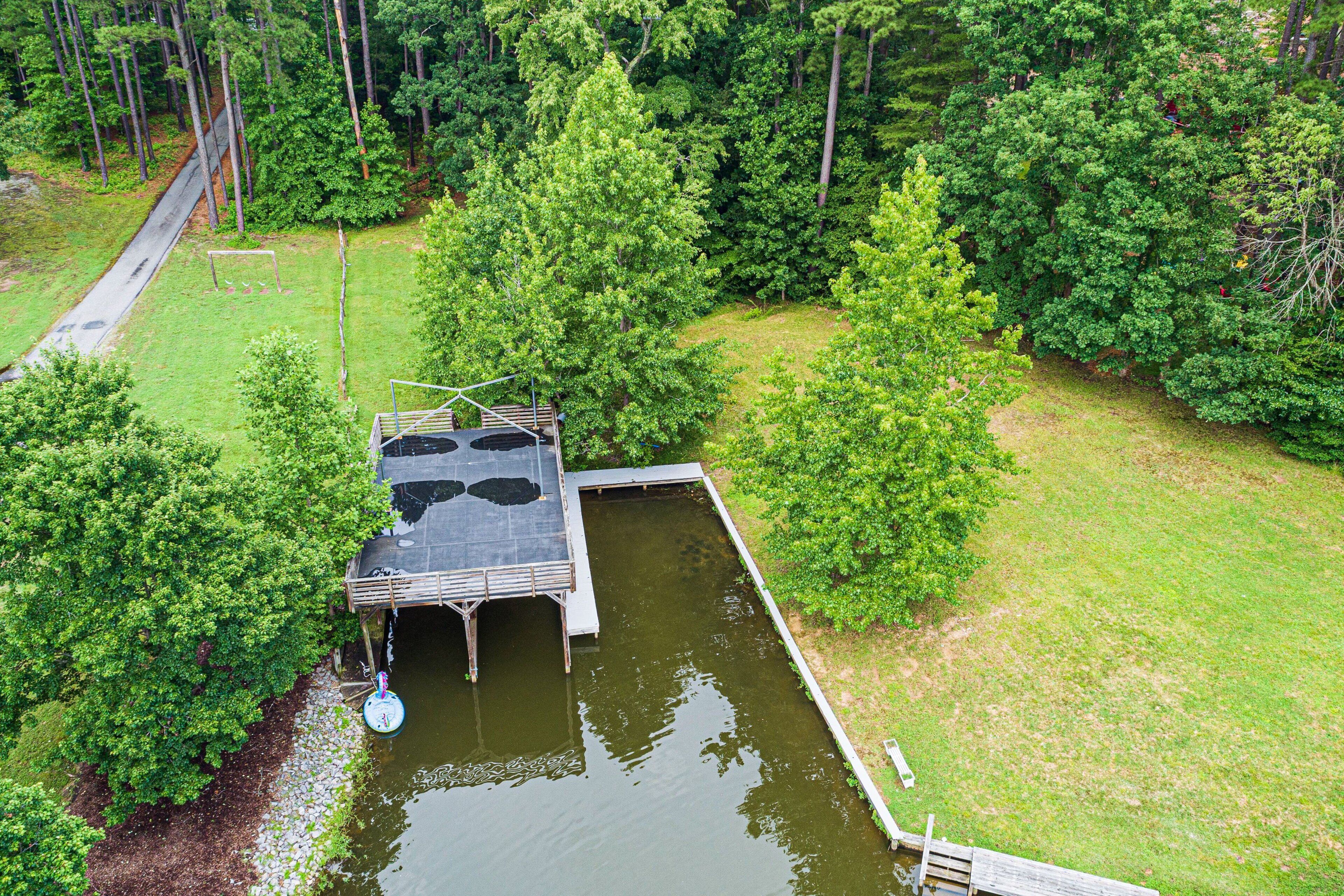 A lakeside cabin with a dock, surrounded by dense forest.