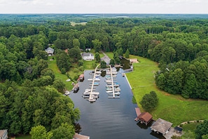 An aerial view of a marina with boats docked, surrounded by lush greenery and residential properties. - Lakefront Home With Boat Mooring, Deck, hot Tub, Game Room & Fast Wifi - Dogs OK (Bumpass)