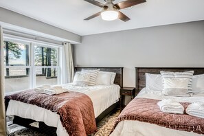 A bedroom with two beds, a ceiling fan, a window with curtains, and a nightstand. - Lakefront Home With Private Dock, Hot Tub, Fireplace, & Central A/C - Free Wifi (Bumpass)