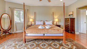 A four-poster bed with a wooden frame, two bedside lamps, a large mirror, and a patterned rug. - Huge Lakefront Home With A/c, Sunroom, Boat Ramp, Wifi,game Room, Deck, & Kayaks (Louisa)