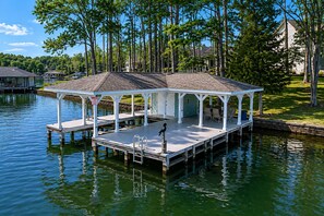 A covered dock with a seating area, a small boat, and a sign indicating a 15-minute wait. - Lake Anna Waterfront Oasis w/ Firepit,boat Dock, dog Friendly (Mineral)