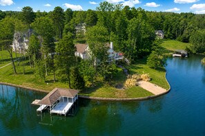 A lakeside property with a dock, a small boat, and a house surrounded by trees. - Lake Anna Waterfront Oasis w/ Firepit,boat Dock, dog Friendly (Mineral)