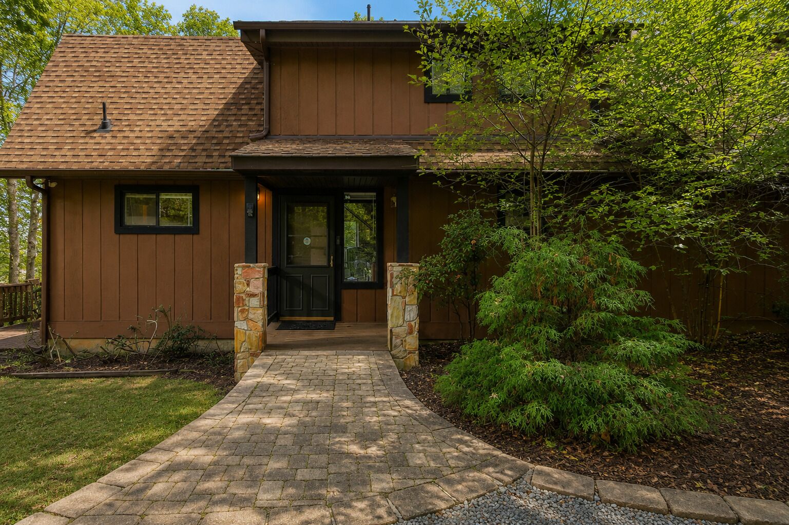 A two-story house with a brick pathway leading to the front door.