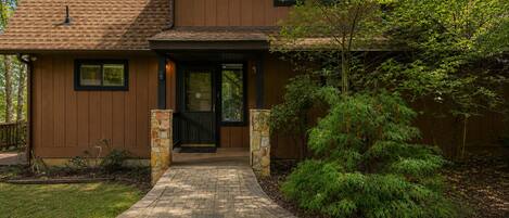 A two-story house with a brick pathway leading to the front door.