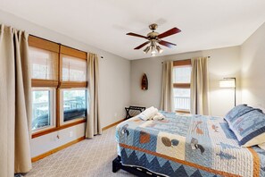 A bedroom with a bed, ceiling fan, windows with curtains, and a view of the outside. - Lake Anna Home on Large Corner lot With Kayaks, Paddleboard, Firepit & Grill (Bumpass)
