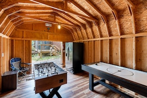 Espaço de lazer coberto com mesa de futebol de mesa, mesa de bilhar e área de estar.