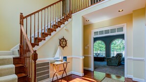 A staircase with wooden railings, a small table with a lamp, and a rug on the floor. - Lakefront Home With Boat Dock, Private Firepit & Game Room - Dog-friendly (Bumpass)