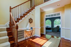 A staircase with wooden railings, a small table with a lamp, and a rug on the floor. - Lakefront Home With Boat Dock, Private Firepit & Game Room - Dog-friendly (Bumpass)