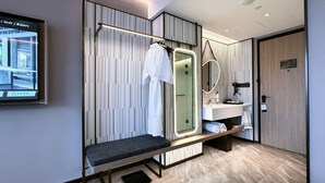 A modern bathroom with a bench, a mirror, a towel rack, and a shower. - Wanda Moments Zhuhai (Zhuhai)