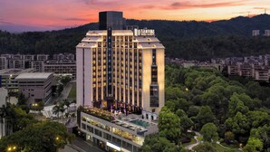 A multi-story hotel with a rooftop pool and a sign indicating 'Wanda Moments.' - Wanda Moments Zhuhai (Zhuhai)