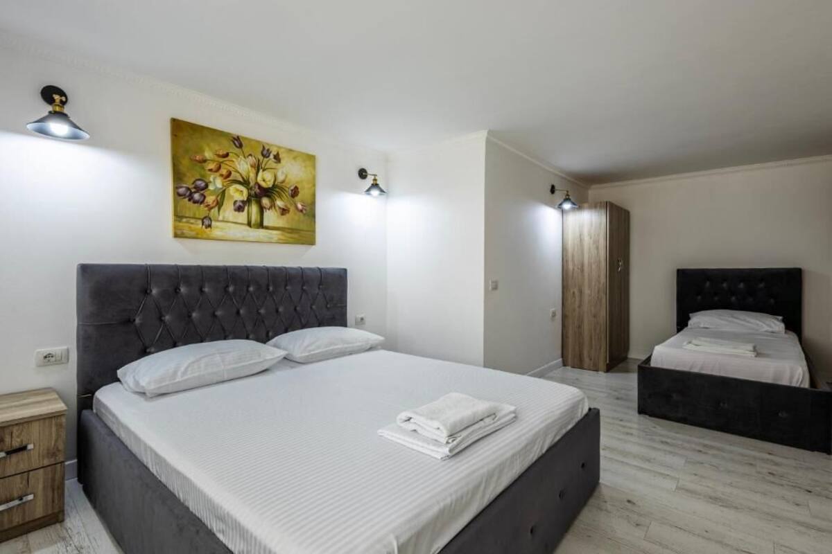 Ein Schlafzimmer mit einem großen Bett, einem Nachttisch, einem Kleiderschrank und einem Gemälde an der Wand.