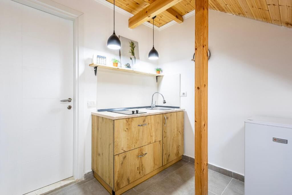 Une cuisine compacte avec des meubles en bois, un évier et des luminaires suspendus.