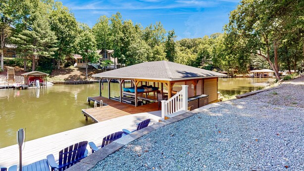 A lakeside gazebo with a wooden deck, a dock, and a small building with a covered area. - Lakefront House With Breathtaking Views, Private Dock & Boat Launch (Mineral)