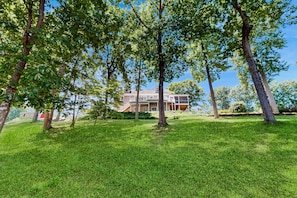 A house with a well-maintained lawn and trees in the foreground. - Lakefront House With Breathtaking Views, Private Dock & Boat Launch (Mineral)