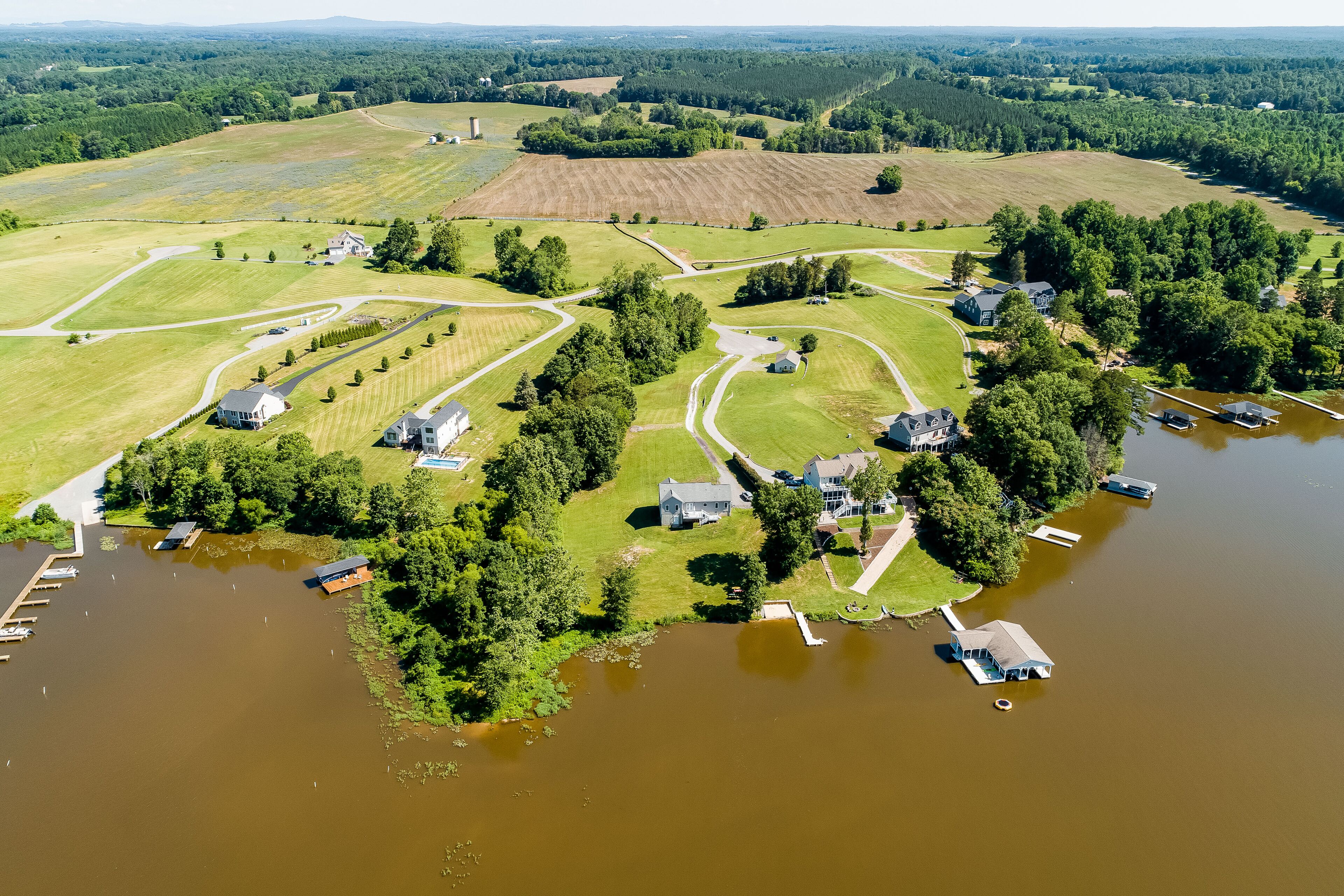 Vista aérea de uma propriedade à beira do lago, com várias casas, um píer e uma rede de estradas.