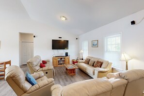 A living room with a sofa, armchair, and a TV. - Two-story, Lakefront Getaway With Dock, Beach, Grill, 2 Kayaks, 2 Canoes, AC (Orange)