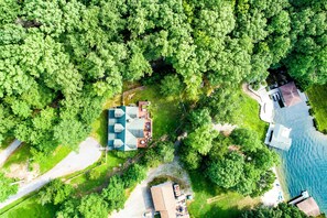 An aerial view of a property with a swimming pool, a boat dock, and a house surrounded by dense greenery. - Luxurious Lakefront Cabin With hot Tub, Game Room, & Washer/dryer- dog Friendly (Bumpass)