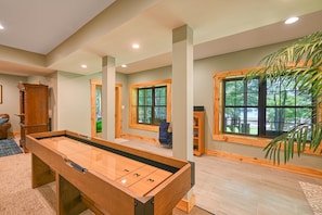 A pool table in a room with large windows, wooden beams, and a bookshelf. - Luxurious Lakefront Cabin With hot Tub, Game Room, & Washer/dryer- dog Friendly (Bumpass)