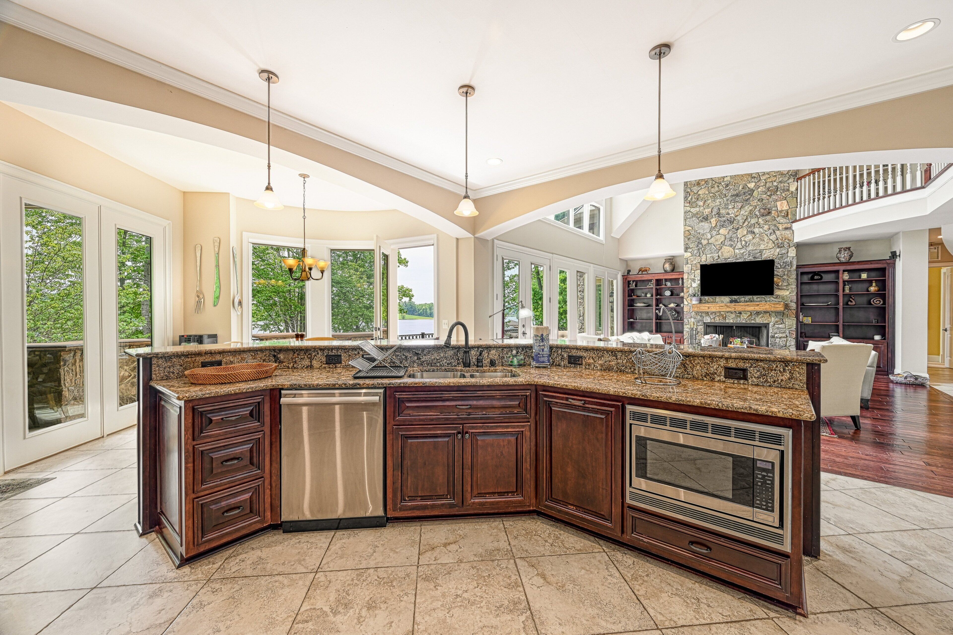 A spacious kitchen with a large island, built-in appliances, and a stone accent wall.