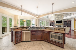 A spacious kitchen with a large island, built-in appliances, and a stone accent wall.