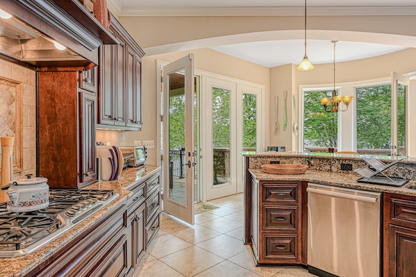 A kitchen with granite countertops, a stove, and a dishwasher. - Spacious Waterfront House With Private hot Tub, Sauna, Pool Table (Mineral)